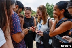 Empleados del Senado de EEUU reaccionan al ver en un video de prensa cómo eran evacuados con supervisión de la policía el 2 de agosto de 2023, tras una llamada no confirmada de la existencia de un tirador activo en el edificio federal.