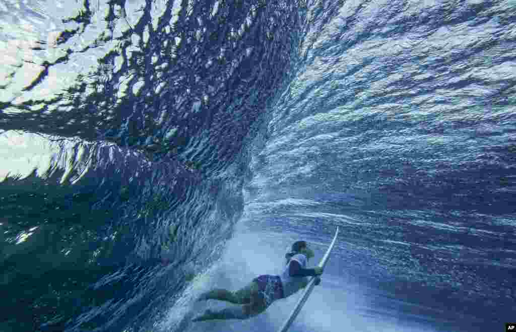 Brisa Hennessy of Costa Rica duck-dives a wave in the women's surfing bronze medal final of the surfing competition at the 2024 Summer Olympics, Aug. 5, 2024, in Teahupo'o, Tahiti.