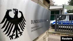 FILE - Sebuah kendaraan polisi melewati tanda di pintu masuk Mahkamah Agung Federal Jerman Bundesgerichtshof di Karlsruhe, Jerman, 8 Desember 2022. (REUTERS/ Tilman Blasshofer).