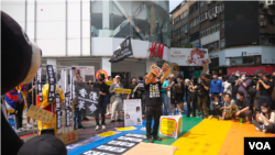 在台流亡港人与香港青年团体等2024年3月23日于台北发起街头集会，以穿插行动剧的方式，谴责当日生效的香港《基本法》第23条 (美国之音特约记者黄丽玲拍摄)。