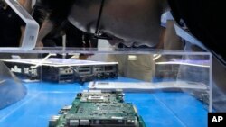 Posjetilac gleda čip prikazan na štandu kineske kompanije Kunlun Core na Svjetskoj konferenciji o umjetnoj inteligenciji u Šangaju. (24. jula 2023.)