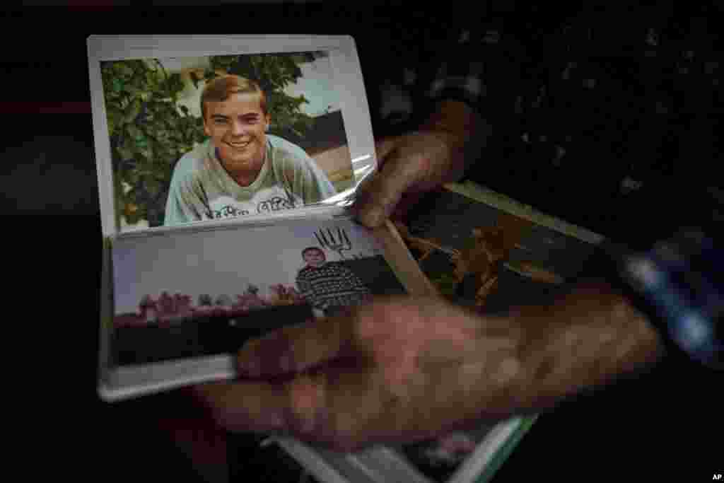 Oleksandr Turovskyi, cuyo hijo Sviatoslav, de 35 años, estaba entre los ocho hombres ejecutados en un terreno baldío en el suburbio de Bucha en marzo de 2022, mira fotografías de su hijo en su departamento en Bucha, Ucrania, el sábado 30 de marzo de 2024.&nbsp;