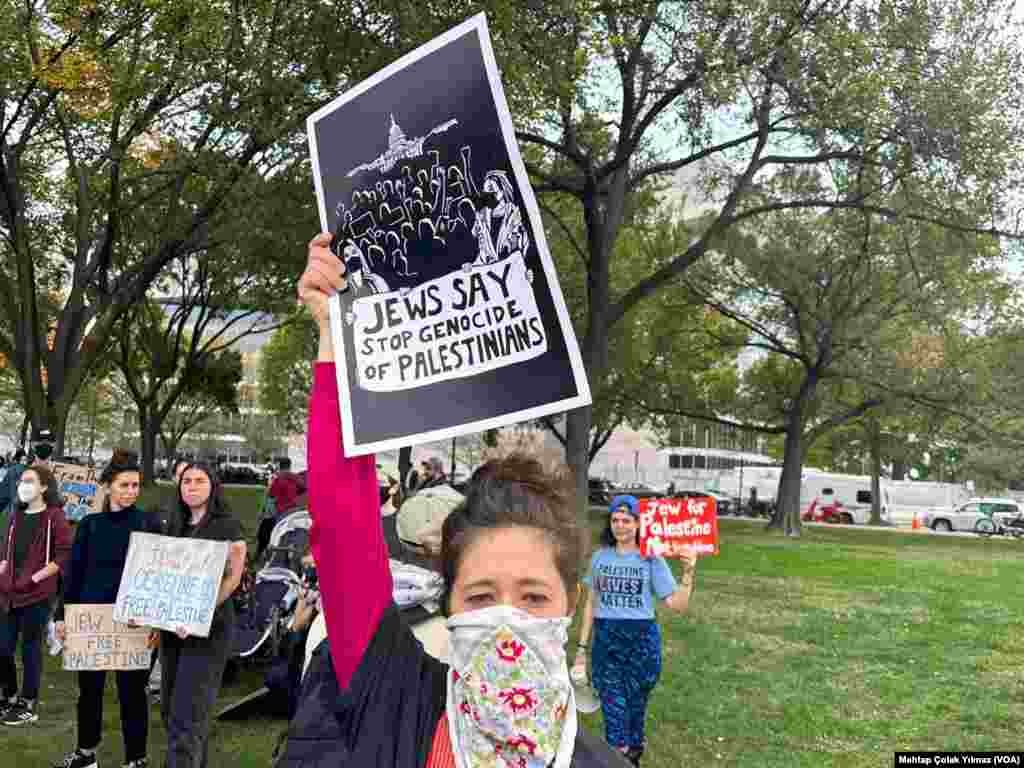 20 October 2023 - Washington'da Filistin'e destek mesajıyla düzenlenen eyleme katılan bir kişi "Yahudiler, Filistinliler'e karşı soykırıma hayır diyor" yazılı pankart taşıyor.