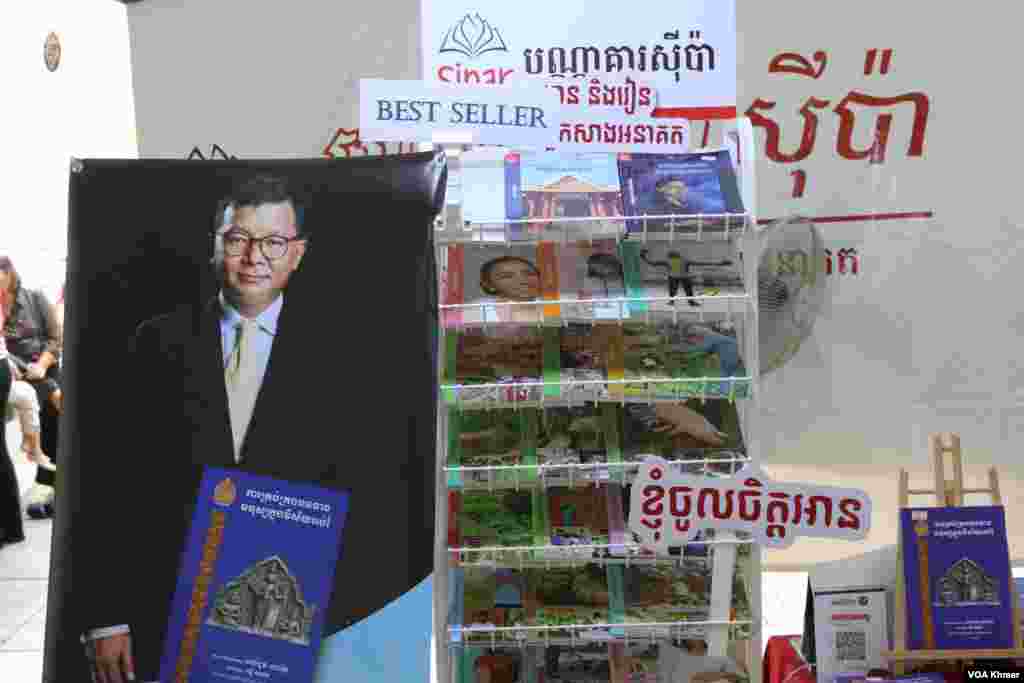 ធ្នើរ​ដាក់​លក់​សៀវភៅ​ក្នុង​ស្តង់​សៀវភៅ​មួយកន្លែង​ក្នុង​កម្មវិធី​ពិព័រណ៌​សៀវភៅ​ក្នុង​ទិវា​ជាតិ​អំណាន​លើក​ទី​៩ នៅ​វិទ្យាស្ថានបច្ចេកវិទ្យាកម្ពុជា ក្នុង​រាជធានី​ភ្នំពេញ នាថ្ងៃទី​៩ ខែ​មីនា ឆ្នាំ​២០២៤។ (សើ ដាវី/វីអូអេ)
