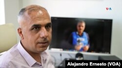 Mohamed Barguti, director de informativos de Palestine TV. Al fondo una foto del reportero Mohamed Abu Hatab, que murió recientemente en Gaza junto a toda su familia cuando un misil israelí impactó en su vivienda.