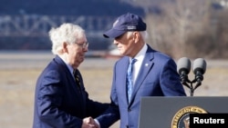 El presidente de EEUU, Joe Biden (der.), le da la mano al líder republicano del Senado, Mitch McConnell (republicano por Kentucky), durante un evento para promocionar el nuevo puente Brent Spence sobre el río Ohio entre Covington, y Cincinnati, Ohio, el 4 de enero de 2023.