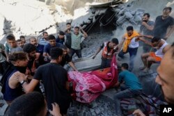 Warga Palestina membawa jenazah dari bawah reruntuhan rumah yang hancur pasca serangan udara Israel di Kota Gaza, 4 November 2023. (Foto: AP)