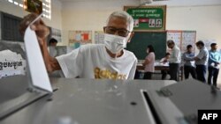 A man casts his vote at a polling station in Phnom Penh on July 23, 2023 during the general elections. (Photo by TANG CHHIN SOTHY / AFP)