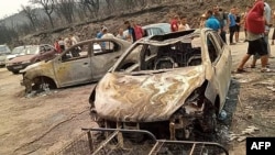 This handout picture released on the Facebook page of Radio Soummam Bejaia on July 24, 2023, shows vehicles burnt in Algeria's wildfires, in the town of Toudja, as temperatures hit 48 degrees Celsius.