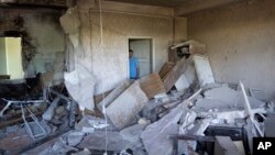Vladimir Golubenko looks at his office damaged by a drone during a night attack, in Kyiv, May 28, 2023. 