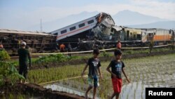 Sejumlah warga berkumpul di lokasi tabrakan antara kereta Turangga dan kereta lokal Bandung Raya di Cicalengka, Jawa Barat, pada 5 Januari 2024. (Foto: Antara Foto/Raisan Al Farisi/via Reuters)