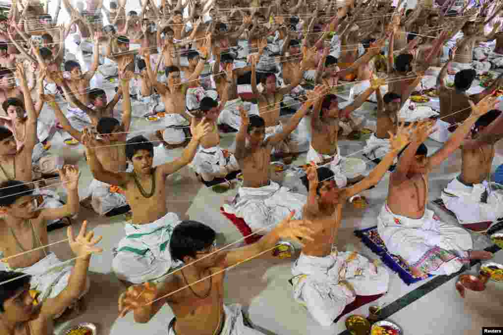 Brahmin Hindu boys take part in the "janeu" (sacred thread), also called "yagnopavit" changing ceremony outside a temple on the occasion of Raksha Bandhan festival in Ahmedabad, India.