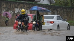 Waendesha bodaboda wakiwa kwenye barabara iliyofurika kutokana na mvua kubwa iliyonyesha mjini Mombasa Novemba 3, 2023. Picha na SIMON MAINA / AFP.