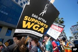 Los manifesantes llevan carteles afuera de Netflix durante un mitin del Sindicato de Escritores el jueves 13 de julio de 2023 en Los Ángeles. (Foto AP/Mark J. Terrill)