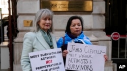 2023年2月13日，人權活動人士海倫娜·肯尼迪（Helena Kennedy）（左）和拉希瑪·馬赫穆特 （Rahima Mahmut） 舉著標語牌在倫敦英國外交部外面抗議。