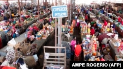 Foto de arquivo: Pessoas fazem compras num mercado em Luanda, Angola, em 19 de janeiro de 2018. (Photo by AMPE ROGERIO / AFP)