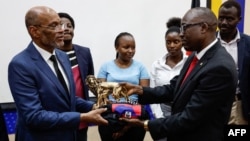 Waziri Mkuu wa Haiti Ariel Henry,(L) akipokea zawadi kutoka kwa Katibu Mkuu, Wizara ya Mambo ya Nje Dkt. Abraham Korir Sing'Oei huko Nairobi Machi 1, 2024. Picha na SIMON MAINA / AFP