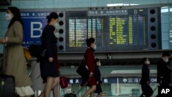 អ្នក​ដំណើរ​និង​បុគ្គលិក​អាកាសយានដ្ឋាន​​ដើរនៅ​ក្នុង​អាកាសយានដ្ឋាន​អន្តរជាតិ​ប៉់េកាំង​កាលពីថ្ងៃទី​២៣ មេសា ឆ្នាំ២០២៣។