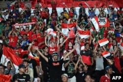 Sorak sorai suporter Indonesia menjelang dimulainya pertandingan final sepak bola putra antara Indonesia dan Thailand pada Pesta Olahraga Asia Tenggara (SEA Games) ke-32 di Phnom Penh, 16 Mei 2023. (MOHD RASFAN / AFP)