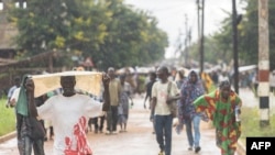 Pessoas deslocadas da província de Cabo Delgado caminham pelas ruas de Namapa, distrito de Erati, em Nampula, Moçambique, a 27 de fevereiro de 2024.