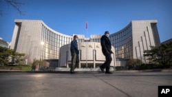 資料照片：戴著口罩的行人從北京的中國人民銀行前走過。（2023年3月3日）