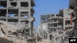 Раселените Палестинци ги транспортираат своите работи на количка со коњ среде урнатините на куќите уништени од израелските бомбардирања во Кан Јунис во јужниот дел на појасот Газа, 6 март 2024 година