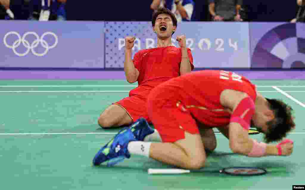 Wei Keng Liang and Chang Wang of China celebrate after winning the match against Fajar Alfian and Muhammad Rian Ardianto of Indonesia during the men's doubles badminton quarterfinals at the Porte de la Chapelle Areana in Paris, France.