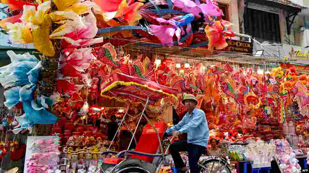 A cyclo driver passes by a shop selling decorative items in Hanoi ahead of the Mid-Autumn Festival.