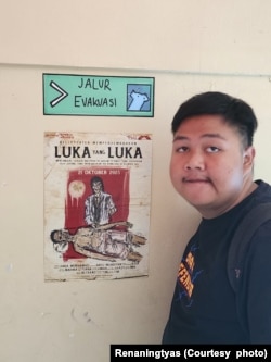 Kenobi Haidar Akmal berfoto di samping poster hasil karyanya, Tangerang Selatan, 21 Oktober 2023. (Foto: Renaningtyas/koleksi pribadi)