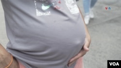 En la imagen una mujer embarazada toca su vientre (Foto: Juan Hernández, VOA)