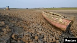 FILE - Sebuah perahu kayu terdampar di dasar sungai Bendungan Dawuhan yang kering kerontang saat musim kemarau di Madiun, Jawa Timur, 5 Oktober 2015. BMKG memperkirakan El Nino akan mulai meningkat pada Agustus dan akan bertahan hingga akhir 2023.(REUTERS/Siswowidodo/Antara Foto)