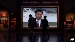 Los visitantes pasan ante una pantalla de video que muestra al presidente chino Xi Jinping en el museo del Partido Comunista de China en Beijing, el 19 de octubre de 2023.