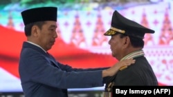 Presiden Joko Widodo memberikan penghargaan jenderal kehormatan bintang empat kepada Menteri Pertahanan Prabowo Subianto saat bertemu dengan perwira tinggi TNI dan Polri di Mabes TNI di Jakarta pada 28 Februari 2024. (Foto: Bay Ismoyo/AFP)