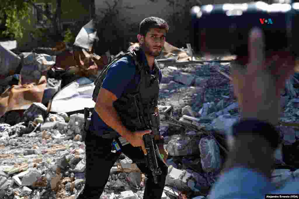 Un miembro del dispositivo de seguridad del jefe de la diplomacia europea Joseph Borrell camina entre los escombros del kibutz Be'eri, uno de los más afectados por los ataques de Hamás el pasado 7 de octubre.