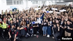 特斯拉行政總裁埃隆·馬斯克與上海特色超級工廠的工人們合影。（2023年5月31日）