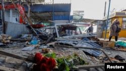 俄占城市顿涅茨克的一个市场遭到炮击后，一束纪念死难者的鲜花摆放在废墟上。（2024年1月22日）