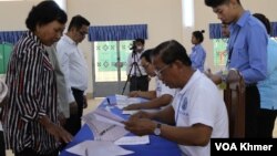 រូបឯកសារ៖ មន្ត្រី គ.ជ.ប ផ្ទៀងផ្ទាត់ឈ្មោះអ្នកបោះឆ្នោត នៅក្នុងការបោះឆ្នោតជាតិអាណត្តិទី ៧ ដែលអវត្តមានគណបក្សប្រឆាំងដ៏ធំមួយ នៅក្រុងតាខ្មៅ ខេត្តកណ្តាល ថ្ងៃទី ២៣ ខែកក្កដា ឆ្នាំ ២០២៣។ (លាស់ លីបលីប/វីអូអេ)