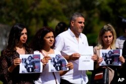 Sejumlah wartawan Lebanon memegang foto mendiang jurnalis video Reuters, Issam Abdallah, dalam demo di depan markas PBB di Beirut, Lebanon, 15 Oktober 2023. Issam tewas oleh oleh tembakan roket Israel saat meliput bentrokan di perbatasan Lebanon. (Foto: Hassan Ammar/AP Photo)