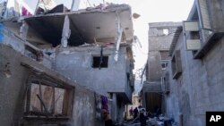 Palestinos inspeccionan un edificio dañado tras los ataques aéreos israelíes contra la ciudad de Khan Younis, Gaza, el 3 de diciembre de 2023.