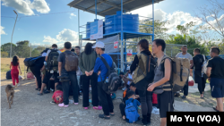 在巴拿马圣文森特(San Vicenter)移民接收点，走出雨林的中国走线移民正在排队等大巴。他们中不少带着孩子一家人走线。巴拿马政府组织的由私人运营的大巴将把他们送往哥斯达黎加。