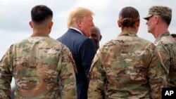 President Donald Trump greets member of the military as he arrives on Air Force One at Wheeler-Sack Army Air Field in Fort Drum, N.Y.