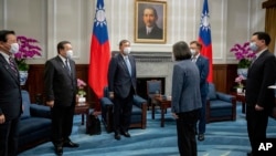 In this photo released by the Taiwan Presidential Office, Taiwan's President Tsai Ing-wen, third right, greets Japanese delegation led by lawmaker and former Defense Minister Shigeru Ishiba at the presidential office in Taipei, Taiwan, July 28, 2022.