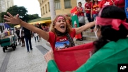 A follower of former Brazilian President Luiz Inacio "Lula" da Silva, who is running for president again, celebrates partial results after general election polls closed in Rio de Janeiro, Brazil, Sunday, Oct. 2, 2022. (AP Photo/Silvia Izquierdo)