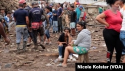 La gente mira la destrucción causada por las fuertes lluvias en Las Tejerías, Venezuela, el domingo 9 de octubre de 2022.