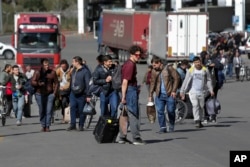 FILE - A group of Russians walk after crossing the border at Verkhny Lars between Georgia and Russia in Georgia, Sept. 27, 2022. Long lines of vehicles formed at a border crossing between Russia's North Ossetia region and Georgia after Moscow announced a partial military mobilization.