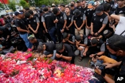 Players and officials of the soccer club Arema FC pray outside the Kanjuruhan Stadium where many fans lost their lives in a crowd surge two days earlier, in Malang, Indonesia, Oct. 3, 2022.
