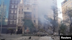 អ្នកពន្លត់ អគ្គិភ័យ​ជួយស្ត្រី​ក្នុងស្រុកម្នាក់​ឱ្យជម្លៀសចេញពី​អគារលំនៅដ្ឋាន​ដែលត្រូវបាន​បំផ្លាញ​ដោយការវាយប្រហារ​ដោយ​យន្តហោះគ្មានមនុស្សបើក(ដ្រូន)​របស់​រុស្ស៊ីនៅ​ទីក្រុងកៀវ នៅ​ថ្ងៃទី១៧ ខែតុលា ឆ្នាំ២០២២ ដែល​អាជ្ញាធរ​ក្នុង​តំបន់​ចាត់ទុកថា​ជា​យន្តហោះ​គ្មាន​មនុស្ស​បើកប្រភេទ Shahed-136 ផលិត​ដោយ​អ៊ីរ៉ង់។