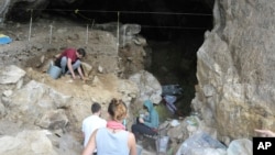 In this photo provided by Bence Viola in October 2022, researchers excavate a cave in the mountains of Siberia, Russia. (Bence Viola via AP)