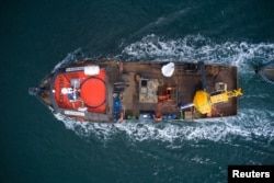 A boat transports a buoy to help avoid ship collisions with whales at the 'Corcovado' gulf area in the coast of Chiloe, Chile, October 10, 2022. (Fundacion MERI/Handout via REUTERS)
