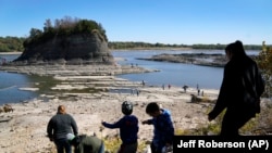 Posjetioci hodaju do turističke atrakcije "Tower Rock" koja je inače u potpunosti okružena vodom i može joj se pristupiti samo čamcima.